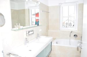 Avenida Mountain Resort A11 في كابرون: حمام به مغسلتين وحوض استحمام ونافذة