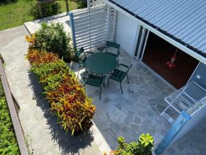 Elle offre une vue sur la terrasse dotée d'une table et de chaises. dans l'établissement Habitation Desrosiers, à Les Trois-Îlets