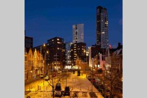 uma cidade iluminada à noite com edifícios altos em Down Town em Eindhoven