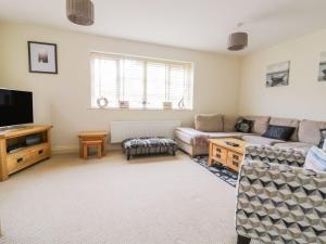 a living room with a couch and a tv at 26 Burtons Mill in Norwich