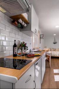 uma cozinha com um balcão com uma garrafa de vinho em CASA DA FALÉSIA 28 - Estúdio em Peniche