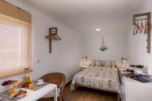a bedroom with a bed and a table with food on it at CASA DA FALÉSIA 28 - Estúdio in Peniche