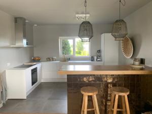 cocina con encimera y 2 taburetes en Luxe villa voor 8 personen met uitzicht over het Veerse Meer, en Kortgene