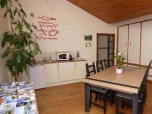 eine Küche und ein Esszimmer mit einem Tisch und Stühlen in der Unterkunft Le bois du drillais in La Gaubretière