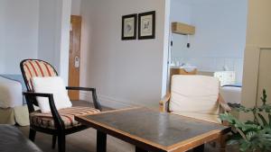 ein Wohnzimmer mit zwei Stühlen und einem Tisch in der Unterkunft Au Petit Hôtel in Québec