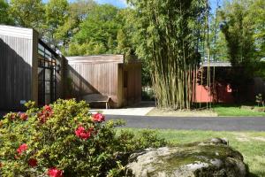 einen Garten mit Felsen, Blumen und einem Zaun in der Unterkunft Le bois du drillais in La Gaubretière