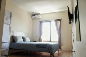 a bedroom with a bed in front of a window at bumimakhraja syariah 4 in Bandung +24 photos