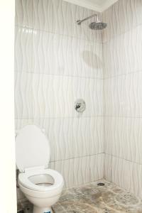 a bathroom with a white toilet and a shower at bumimakhraja syariah 4 in Bandung +19 photos