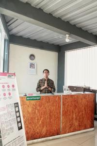 Un homme se tient derrière un comptoir dans un bureau dans l'établissement bumimakhraja syariah 4, à Bandung