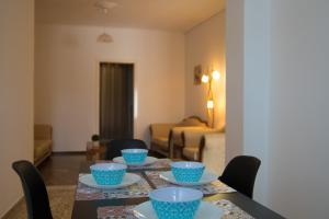 una mesa de comedor con platos y tazones azules en Nikolaos Residence, en Kiato