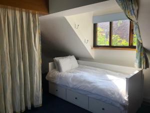 Cama en habitación con ventana y visor en The Game Keeper's Lodge, en Welwyn