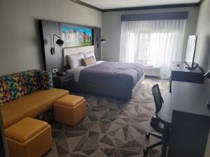 Habitación de hotel con cama y silla en Big Country Hotel & Suites, en Abilene