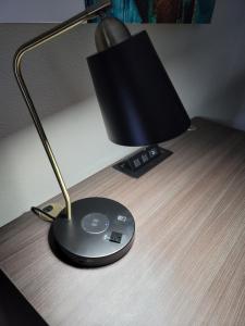 a desk with a lamp and a cd on a table at Big Country Hotel & Suites in Abilene