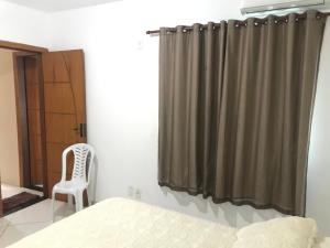 a bedroom with a bed and a shower curtain at Taty Flats in Rio das Ostras