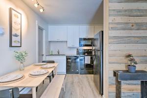 a kitchen with white cabinets and a wooden wall at Park City Condo at Canyons Village with Amenities! in Park City