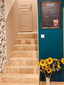 a staircase with a door and a vase of sunflowers at L’ Escale de la Poste in Gourdon