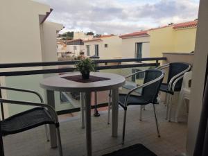 een tafel en stoelen op een balkon met uitzicht bij Vilas Horizonte in Porto Santo