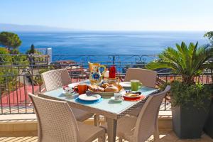stół ze śniadaniem na balkonie z widokiem na ocean w obiekcie casa cloe w Taominie