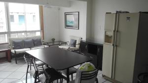a kitchen with a table and a refrigerator and chairs at El Refugio in Punta Hermosa