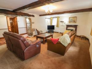 a living room with two couches and a table at Ryecroft Barn in Keighley