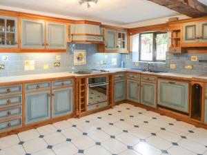 a kitchen with blue cabinets and a white tile floor at Ryecroft Barn in Keighley