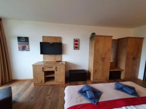 a bedroom with a bed with a television and wooden cabinets at Goisererglück in Bad Goisern