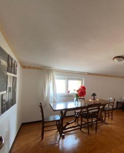 una sala da pranzo con tavolo, sedie e finestra di La casa di Anita a Civita Castellana