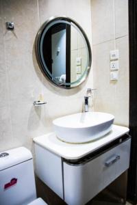 a bathroom with a sink and a mirror on the wall at Zahrat Rozah By Quiet Rooms in Riyadh