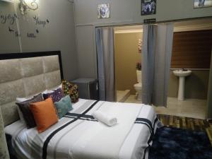 a bedroom with a large bed and a bathroom at Bruno Comfort Suites in Johannesburg