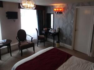 a hotel room with a bed and a chair and a desk at The Engine Inn in Holker