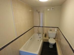 a bathroom with a tub and a toilet and a shower at The Engine Inn in Holker