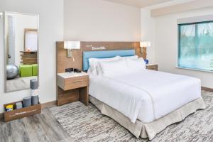 una camera da letto con un grande letto bianco e una scrivania di EVEN Hotel Eugene by IHG a Eugene