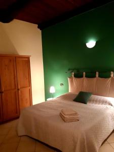 ドモドッソラにあるAppartamento La Mottaの緑の壁のベッドルーム1室(大型ベッド1台付)