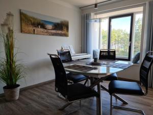 een eetkamer met een tafel en stoelen en een toetsenbord bij FeWo Meerblick Prora in Binz