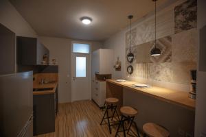 a kitchen with a counter and stools in it at Apartment Nobl plac in Celje