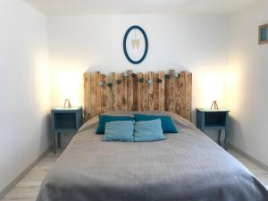 1 dormitorio con 1 cama grande con almohadas azules en Gîte chez Julie et Jp, en Neufchâteau