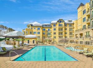 um grande edifício com uma piscina em frente em The Vail Collection at the Ritz Carlton Residences Vail em Vail