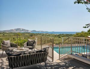 a patio with a table and chairs next to a pool at Aerial View Villas in Lithakia