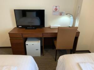 einen Schreibtisch in einem Hotelzimmer mit TV darauf in der Unterkunft BANDE HOTEL OSAKA - Vacation STAY 98144 in Osaka