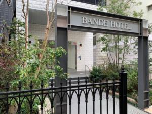 ein Schild für ein Hotel am Ufer hinter einem schwarzen Zaun in der Unterkunft BANDE HOTEL OSAKA - Vacation STAY 98144 in Osaka