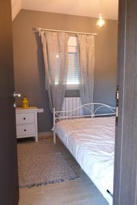 - une petite chambre avec un lit et une fenêtre dans l'établissement Apartmani Jana 2, à Divčibare