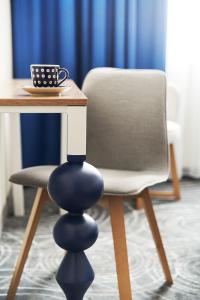 stół i krzesło z filiżanką kawy w obiekcie ibis styles Bolesławiec w mieście Bolesławiec