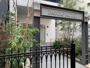 a sign for a bandide hotel behind a black fence at BANDE HOTEL OSAKA - Vacation STAY 98159 in Osaka