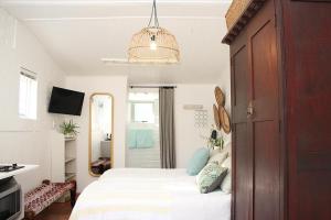 a bedroom with a bed and a chandelier at Courtyard Studio lights and wi fi during load shedding in Stellenbosch