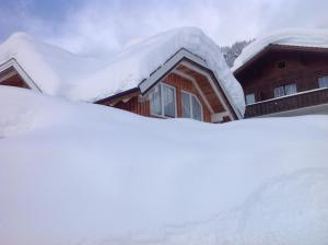 a pile of snow in front of a house at Appartementhaus Finis in Ramsau am Dachstein