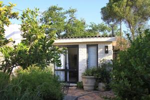 a small house with a door in a garden at Courtyard Studio lights and wi fi during load shedding in Stellenbosch