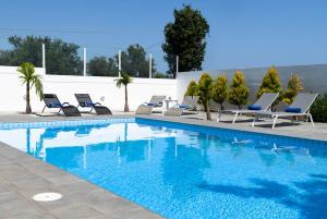 カト・ダラトソにあるMyrto Villa heated poolのラウンジチェア付きのスイミングプール、