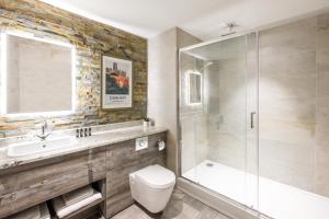 
a bathroom with a toilet, tub, sink and shower at Hotel Indigo - Durham, an IHG Hotel in Durham

