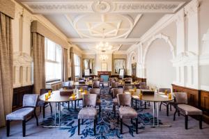 a dining room with tables and chairs and a chandelier at Hotel Indigo - Durham, an IHG Hotel in Durham