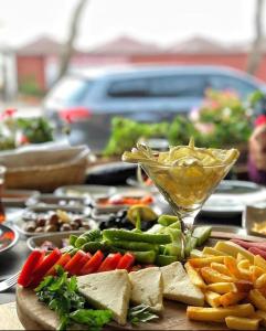 a table full of food with a drink and vegetables at Gelibolu Taş Konak Hotel in Gelibolu